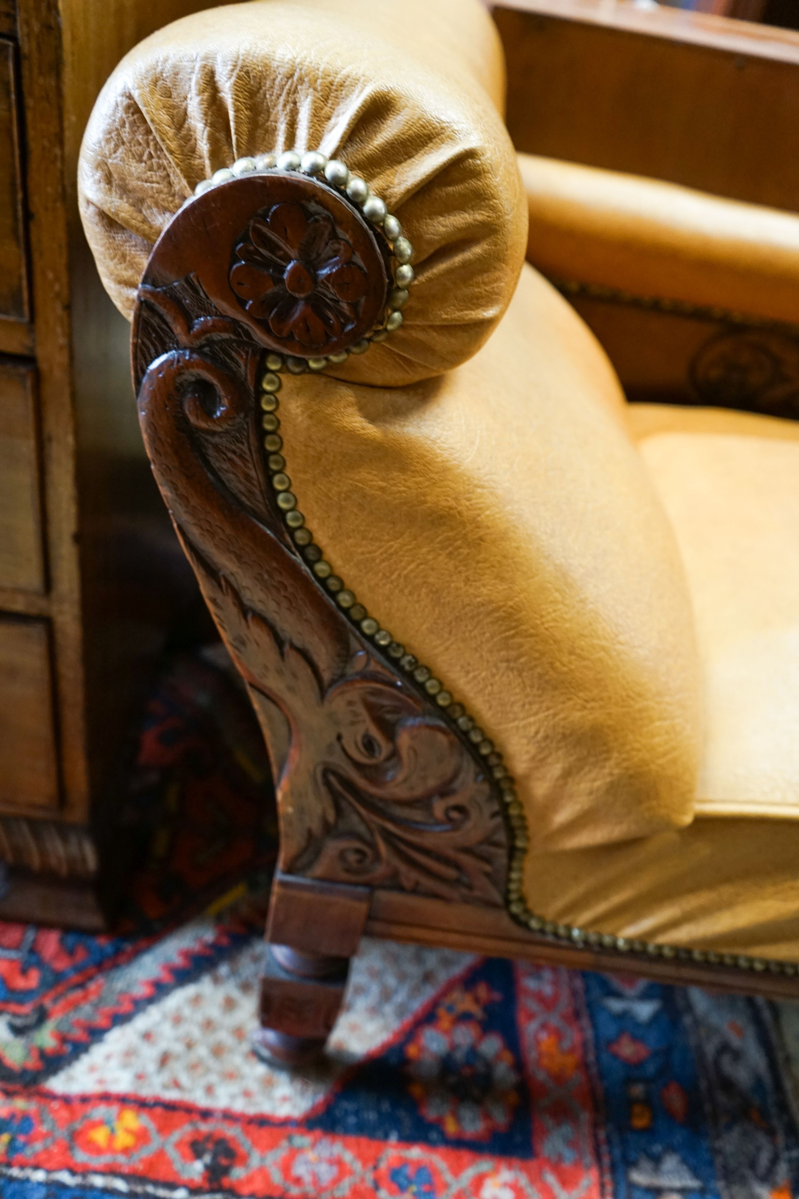 A late Victorian carved mahogany chaise longue with rexine upholstery, length 175cm, depth 60cm, height 74cm